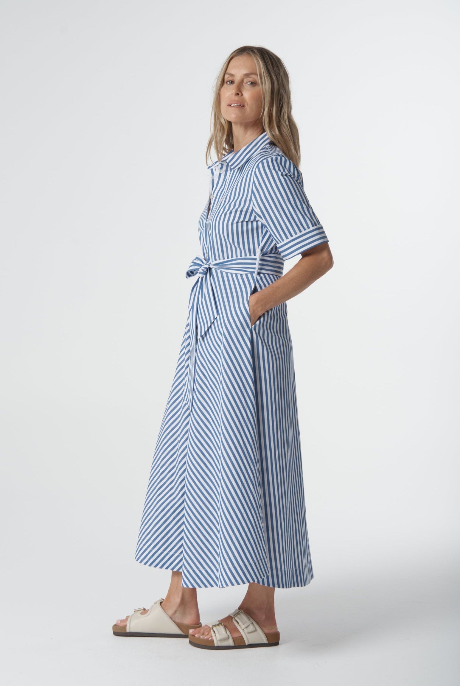 Woman wearing a blue and white striped dress on a white background